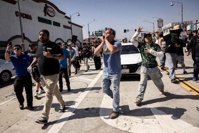 Migrantes celebran luego de expulsar a agentes que intentaban efectuar una redada en el sur de Los Ángeles. Foto Afp