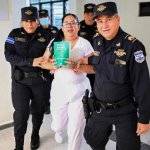 La abogada y activista de derechos humanos salvadoreña, Ruth López, es escoltada por la policía a una audiencia en el centro judicial Isidro Menéndez de San Salvador, el 4 de junio de 2025. Foto Afp