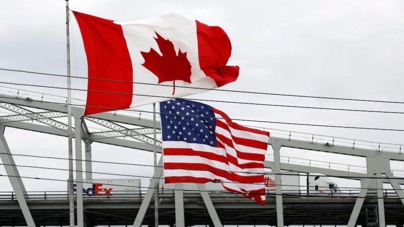 Imagen de archivo de las banderas canadiense y estadunidense izadas en un paso fronterizo. Foto Afp