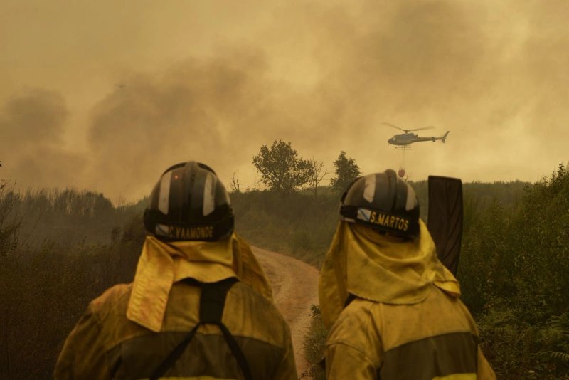 Extinción del fuego en la carretera de acceso a la población de Cualedro, en Galicia, España. Foto Europa Press