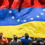 Simpatizantes de Nicolás Maduro portan una gran bandera venezolana durante una marcha en Caracas en apoyo a su reelección. 31 de julio de 2024. Israel Fuguemann / Gettyimages.ru