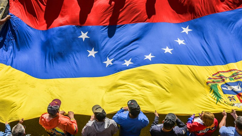 Simpatizantes de Nicolás Maduro portan una gran bandera venezolana durante una marcha en Caracas en apoyo a su reelección. 31 de julio de 2024. Israel Fuguemann / Gettyimages.ru