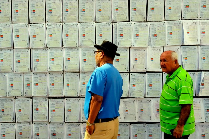Hombres observan copias de actas de votación frente al Centro Logí­stico Electoral donde se realiza el escrutinio especial, en Tegucigalpa, Honduras, el 20 de diciembre de 2025. Foto Xinhua