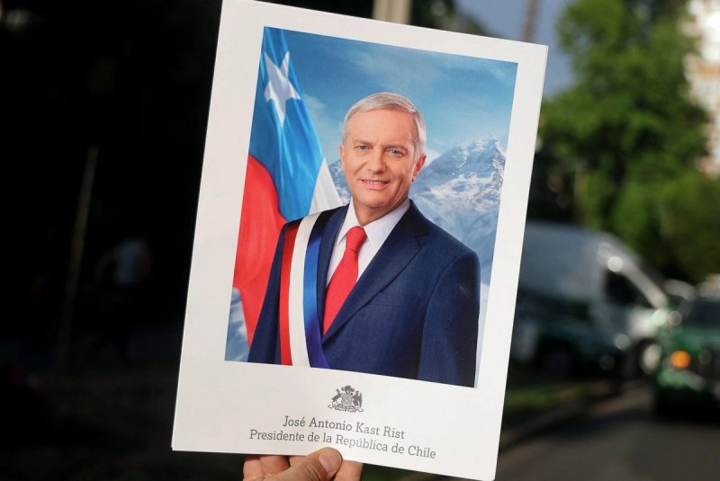 Una persona muestra un cartel con la imagen del candidato presidencial chileno José Antonio Kast, del Partido Republicano, que incluye su nombre y la frase "Presidente de la República de Chile", tras los primeros resultados de la segunda vuelta de las elecciones presidenciales en Santiago el 14 de diciembre de 2025. Foto: Afp