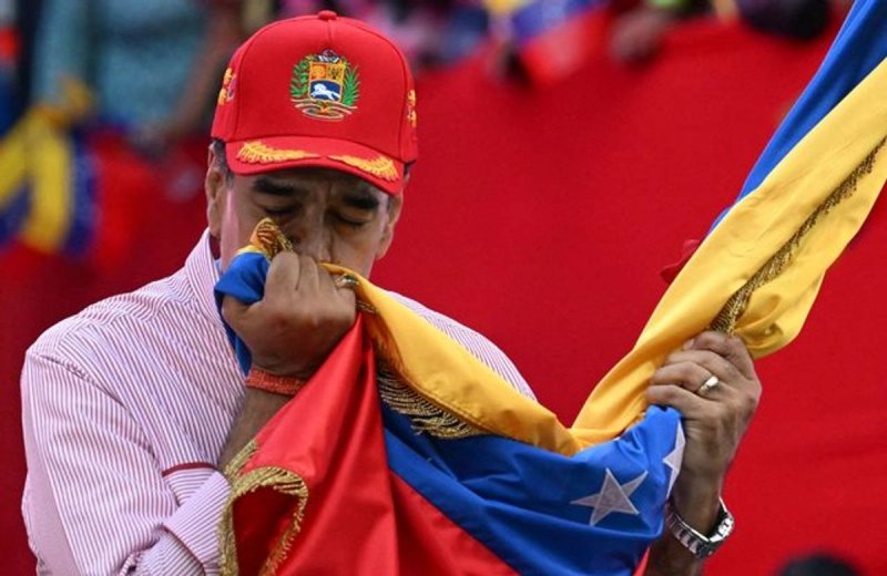 El presidente Nicolás Maduro besa la bandera de Venezuela durante la movilización multitudinaria frente al Palacio de Miraflores. Foto Afp