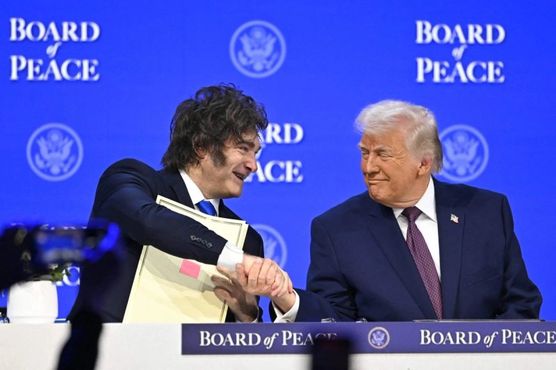 El presidente de Argentnia, Javier Milei, estrecha la mano del presidente de EU, Donald Trump, mientras sostiene un acta fundacional en la reunión de la junta de la paz, durante la reunión anual del Foro Económico Mundial (FEM) en Davos, el 22 de enero de 2026. Foto Afp