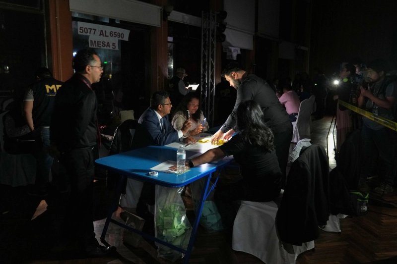 Voluntarios electorales cuentan las papeletas para elegir a los magistrados que representan al Colegio de Abogados ante la Corte de Constitucionalidad, mientras agentes de la Fiscalía General de la República realizan un allanamiento durante un apagón en la Ciudad de Guatemala, el jueves 12 de febrero de 2026. Foto Ap