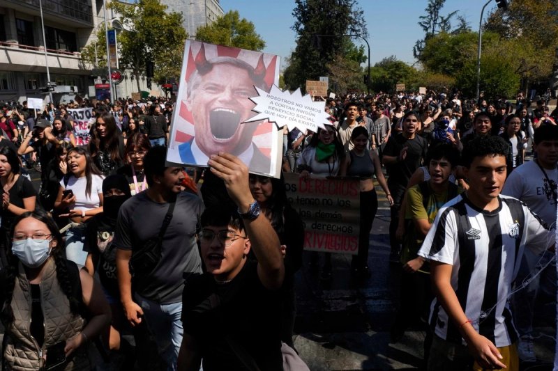 Un joven sostiene una imagen del presidente de Chile, José Antonio Kast, durante una protesta estudiantil contra la propuesta del gobierno de reducir el presupuesto de educación y contra el aumento del precio de la gasolina en Santiago de Chile, el jueves 26 de marzo de 2026. Foto: Ap