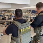Agentes del Servicio de Inmigración y Control de Aduanas de Estados Unidos montan guardia cerca de la sala de salidas del Aeropuerto Internacional Hartsfield-Jackson de Atlanta, Georgia. Los agentes de inmigración se desplegarán en los aeropuertos estadunidenses a partir del lunes con el objetivo de aliviar la creciente congestión en los controles de seguridad, en medio de un conflicto presupuestario que se prolonga desde hace semanas por la campaña de deportaciones masivas del presidente Donald Trump, según informaron las autoridades. Foto AFP