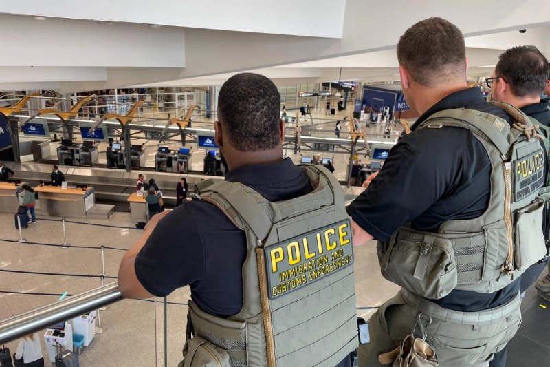 Agentes del Servicio de Inmigración y Control de Aduanas de Estados Unidos montan guardia cerca de la sala de salidas del Aeropuerto Internacional Hartsfield-Jackson de Atlanta, Georgia. Los agentes de inmigración se desplegarán en los aeropuertos estadunidenses a partir del lunes con el objetivo de aliviar la creciente congestión en los controles de seguridad, en medio de un conflicto presupuestario que se prolonga desde hace semanas por la campaña de deportaciones masivas del presidente Donald Trump, según informaron las autoridades. Foto AFP