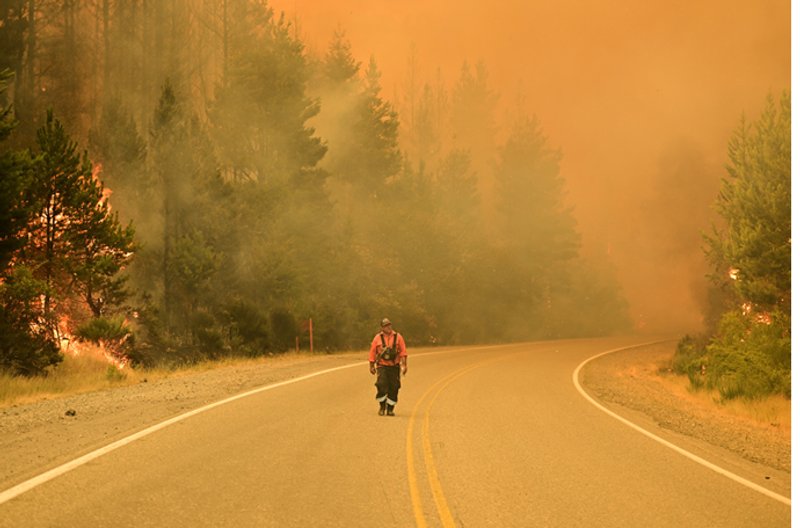Un bombero camina por una carretera mientras los incendios forestales arden en El Hoyo, Patagonia, Argentina, el jueves 8 de enero de 2026. Foto: AP/Maxi Jonas.