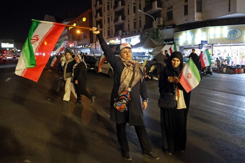 Una mujer ondea una bandera de Irán durante una protesta en contra de las agresiones de Estados Unidos, en calles de la capital Teherán, el 29 de mayo de 2026. Foto Afp