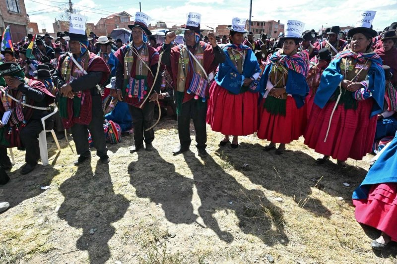 Indígenas con sombreros que llevan letreros con la inscripción "Policía de la Unión" asisten a una reunión de líderes de los "Ponchos Rojos" para discutir el futuro de las protestas que se extienden por más de seis semanas en Tilata, departamento de La Paz, Bolivia, el 18 de junio de 2026. Foto Afp