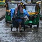 Un hombre empuja una carretilla por una calle parcialmente inundada durante una lluvia en la ciudad de Bengaluru, India, el 12 de junio de 2026. Foto Afp