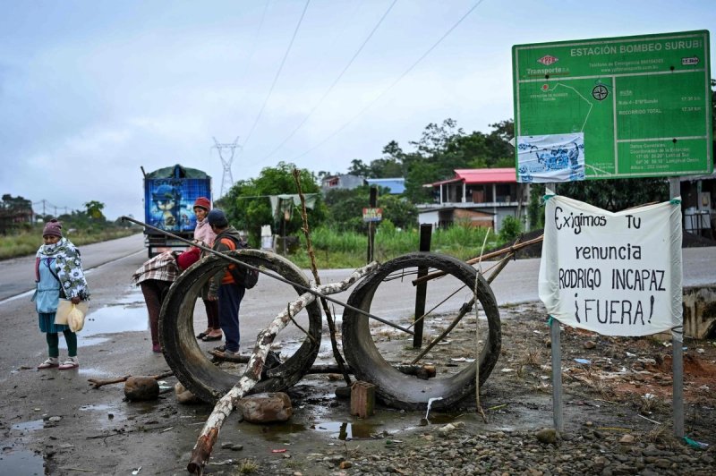Personas esperan el transporte en la carretera que conecta Cochabamba y Santa Cruz, en Cochabamba, Bolivia, el 23 de junio de 2026. Foto Afp
