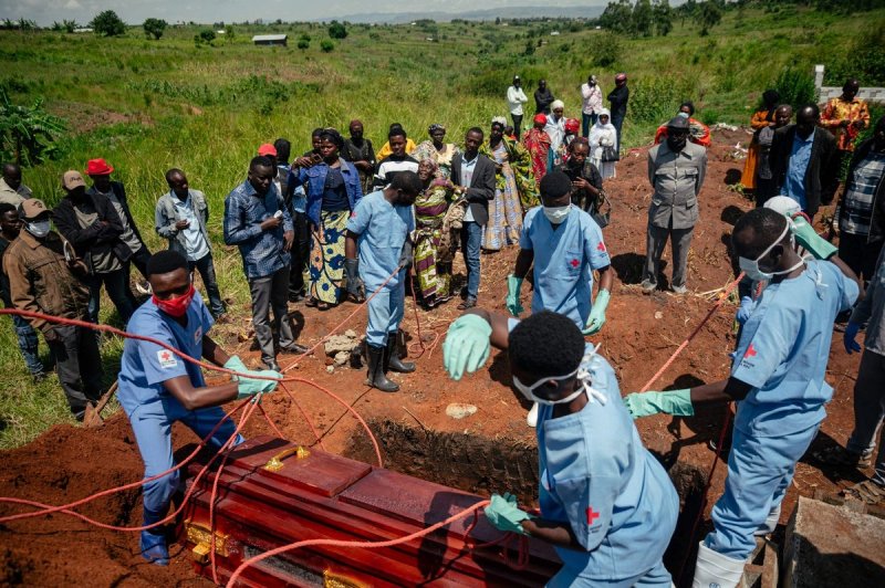 Familiares lloran mientras miembros de un equipo de la Cruz Roja Congoleña se preparan para bajar el ataúd de una mujer presuntamente fallecida por la enfermedad del virus del Ébola, como parte de su entierro seguro en un cementerio de Bunia el 7 de junio de 2026. Foto: Afp