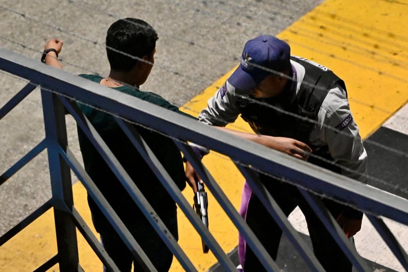 Un agente de seguridad del aeropuerto revisa a un pasajero con un detector de metales portátil fuera del área de llegadas internacionales, luego de que un líder de una banda criminal fuera asesinado a tiros en el Aeropuerto Internacional José Joaquín de Olmedo en Guayaquil, Ecuador, el 17 de junio de 2026. Foto: Afp