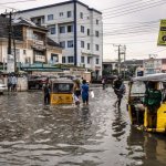 Peatones caminan por una calle inundada en el barrio de Lekki, en Lagos, el 3 de julio de 2026. Foto AFP