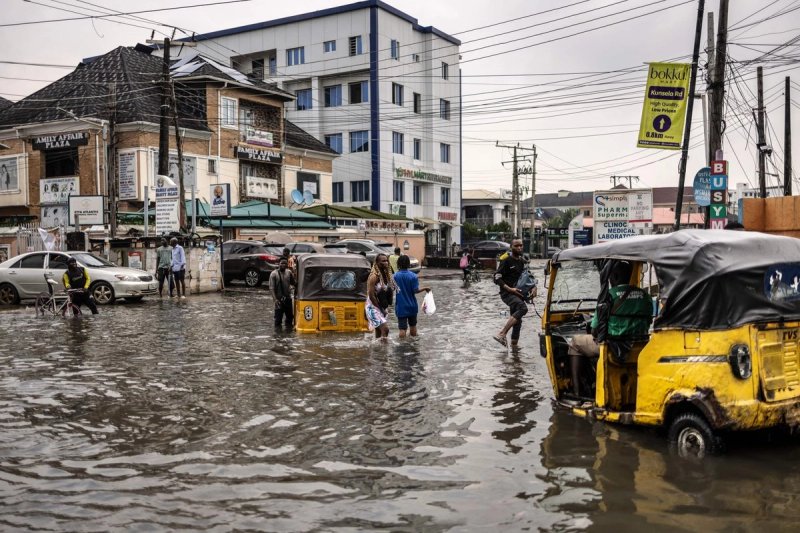 Peatones caminan por una calle inundada en el barrio de Lekki, en Lagos, el 3 de julio de 2026. Foto AFP